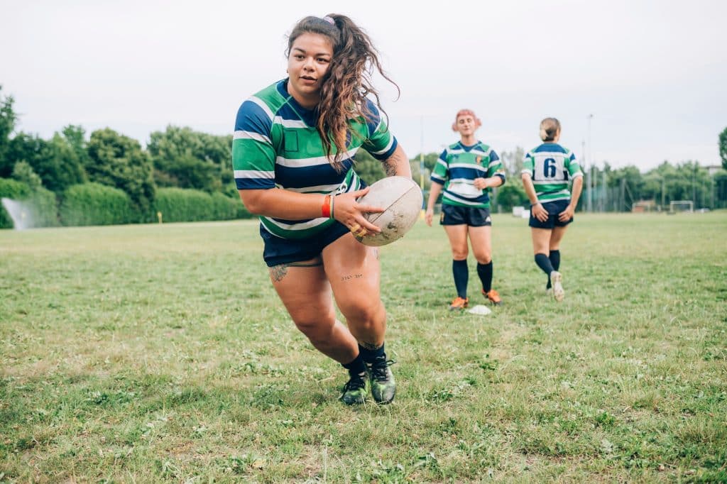 Focused rugby player running with the ball during a match